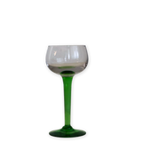A stemmed wine glass with a clear glass bowl and a vibrant green stem and base, isolated on a white background.